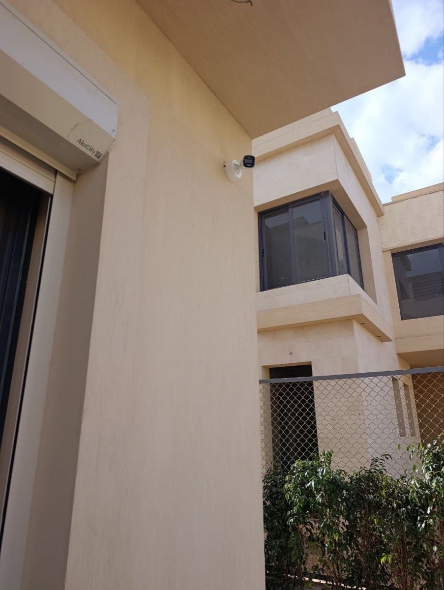 CCTV camera mounted beside a window on the villa's exterior wall