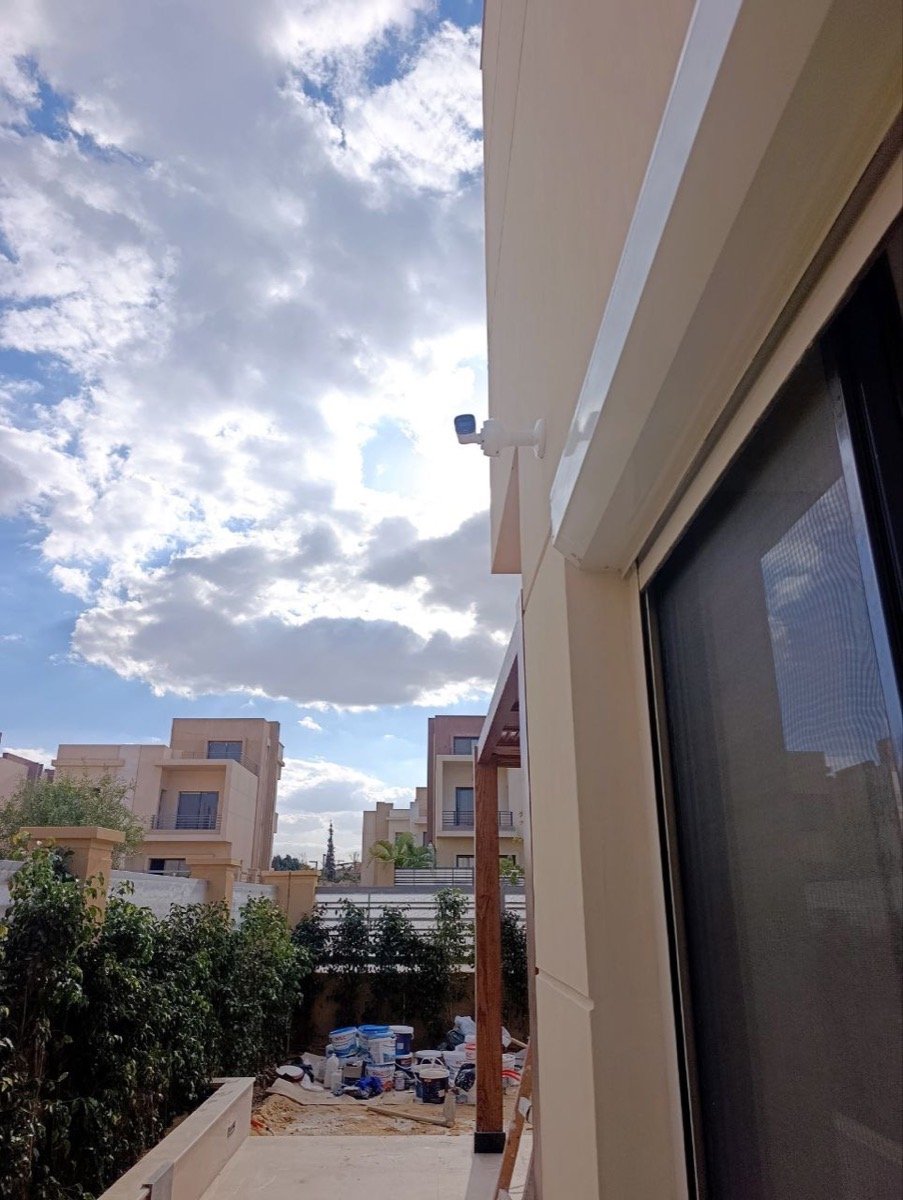 CCTV camera mounted under a terrace overhang, overlooking the back garden