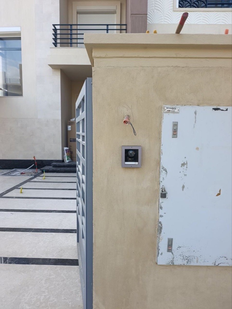 Outdoor video intercom panel mounted beside the gate's electrical panel