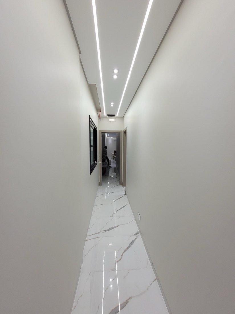 Corridor ceiling with continuous cove lighting and recessed downlights