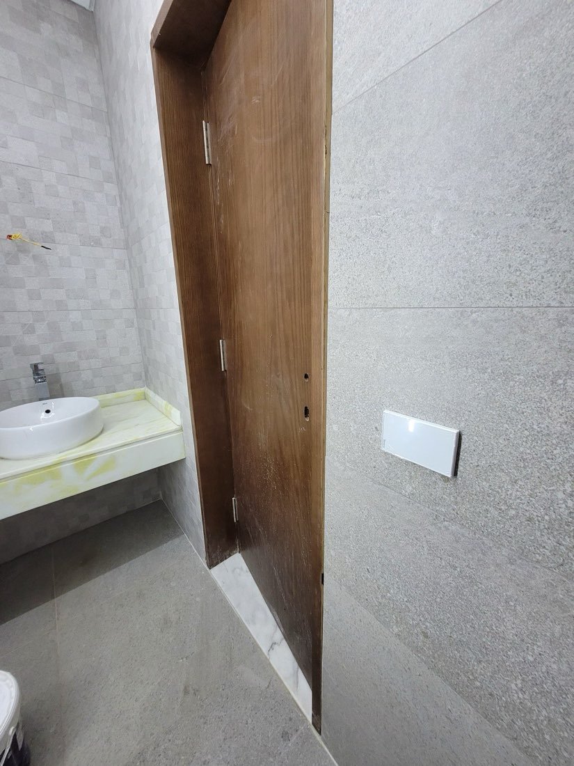 Smart touch switch mounted on stone-textured tile near the bathroom