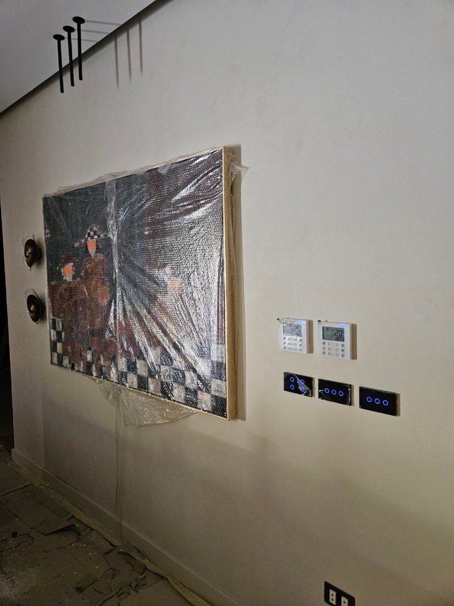 Wall with two climate controllers and three smart touch switch panels, during construction