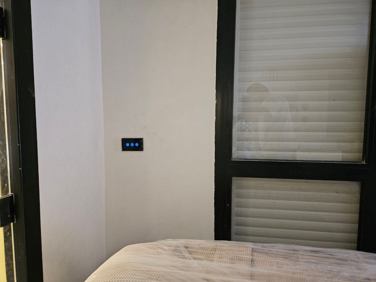 Smart touch switch panel mounted beside a bedroom window